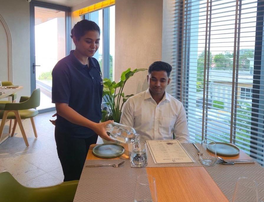 Sevaantha food and beverage professional serving a guest.